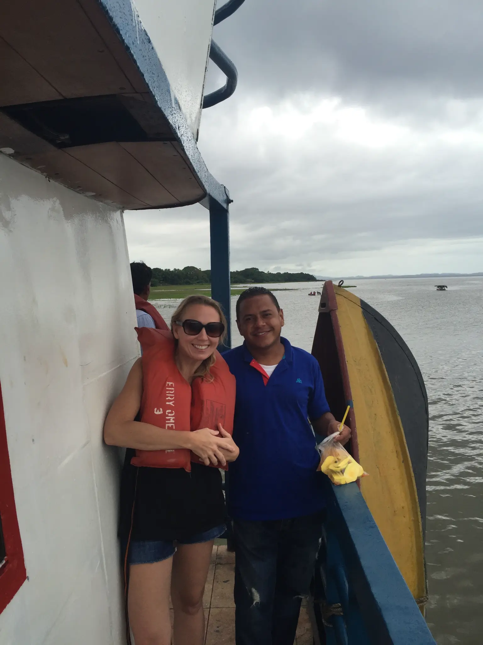 Smiling with a local on the Ometepe ferry, Lake Nicaragua — wearing a life jacket on the crossing
