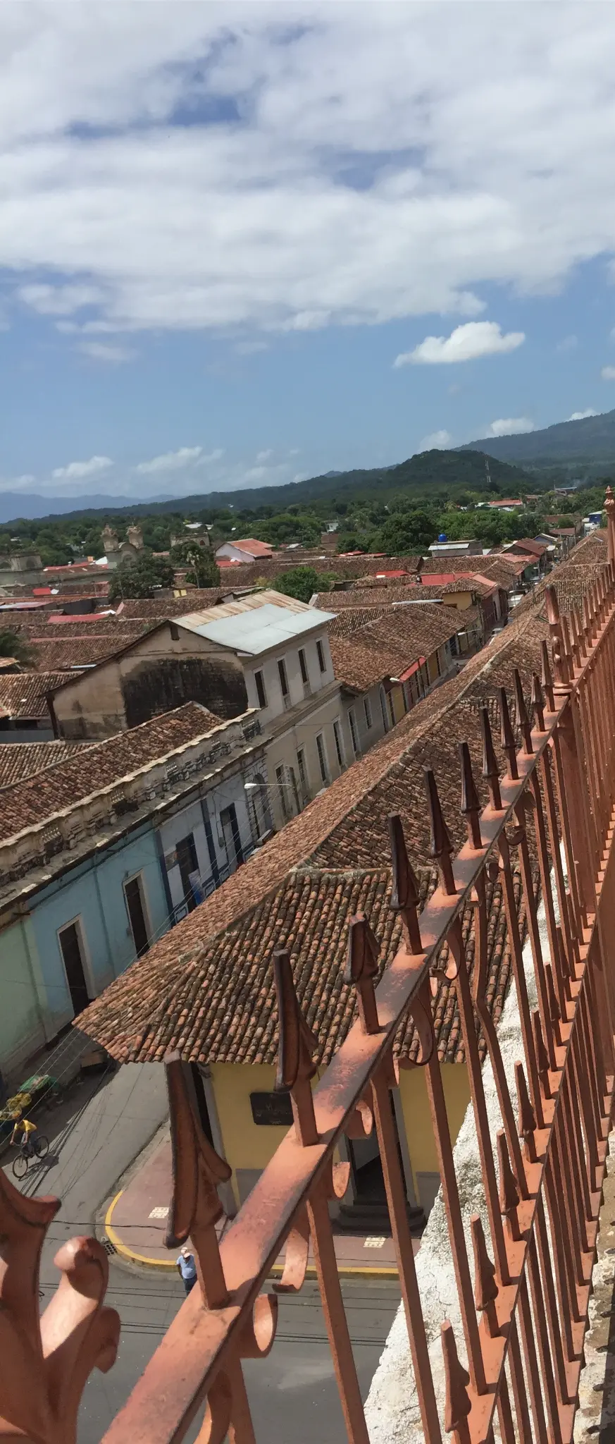 Rooftop view from La Merced bell tower Granada Nicaragua — terracotta rooftops and jungle hills