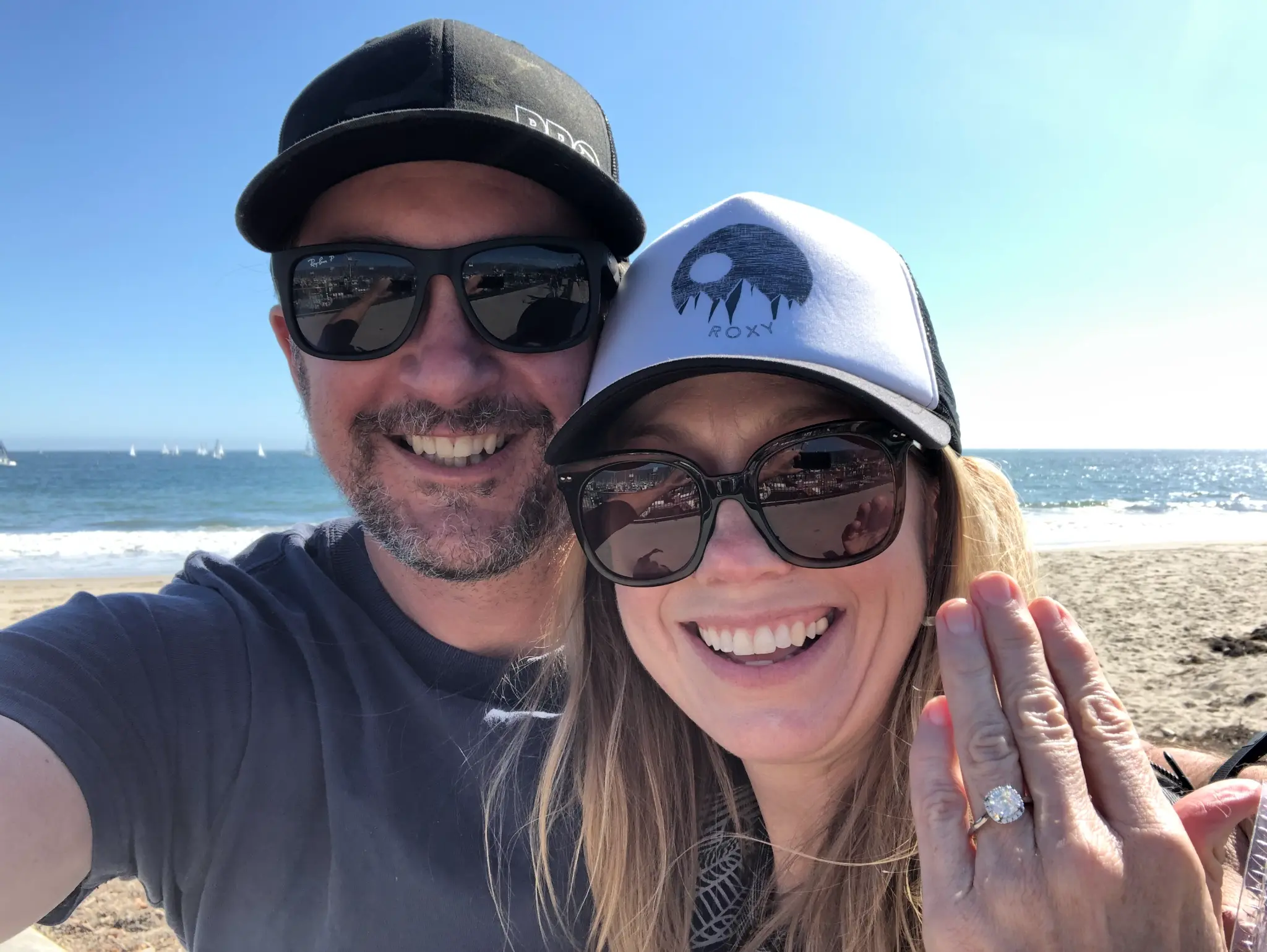 Kristen and her partner on the beach, ring visible — An engagement he would keep entirely private from his world
