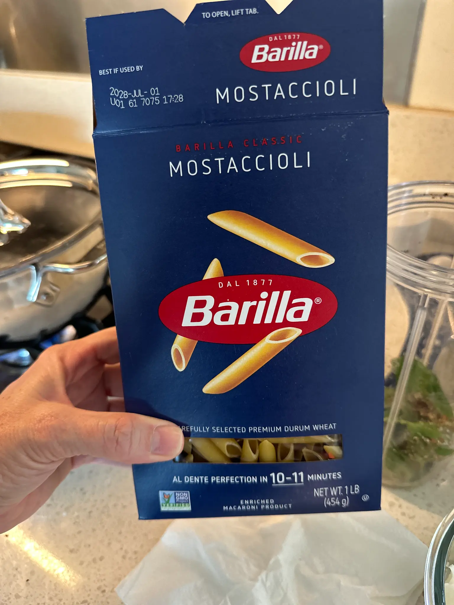 Holding a box of Barilla Classic Mostaccioli pasta