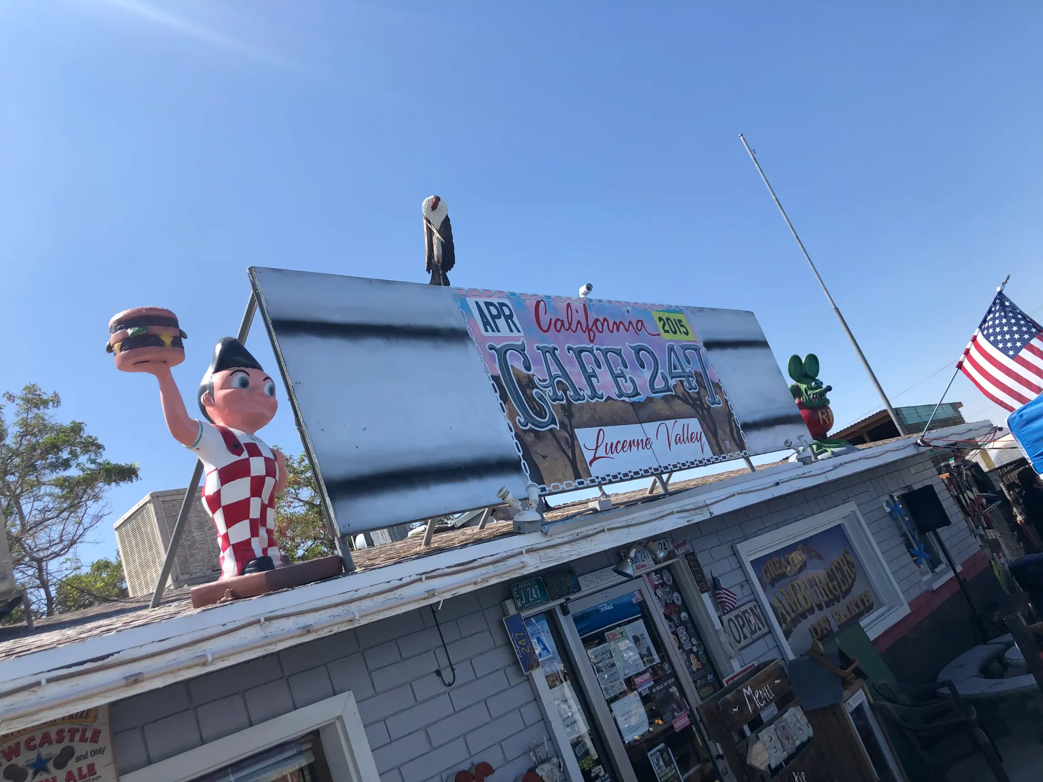 Cafe 247 in Lucerne Valley — Bob's Big Boy statue on the roof holding a burger, colorful signage against a blue sky