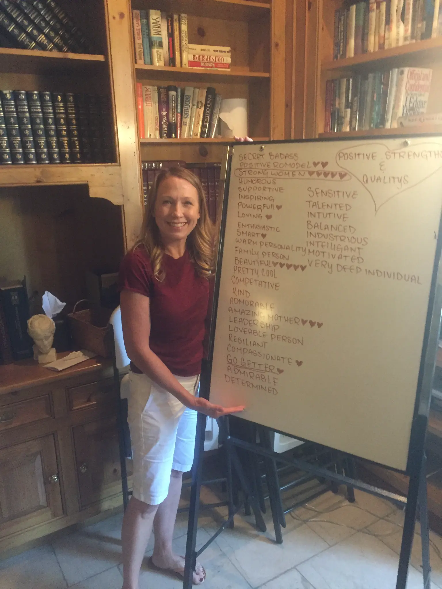 Kristen standing next to a whiteboard listing her positive strengths and qualities